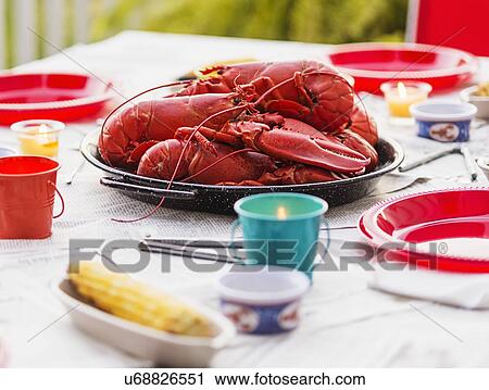 Stock Image - Plate with lobsters on dining table. Fotosearch