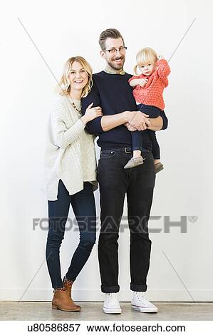 Stock Photo - Portrait of cute girl (2-3) with parents. Fotosearch