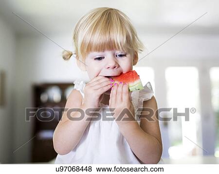 Stock Photo - Portrait of girl (2-3) eating watermelon. Fotosearch