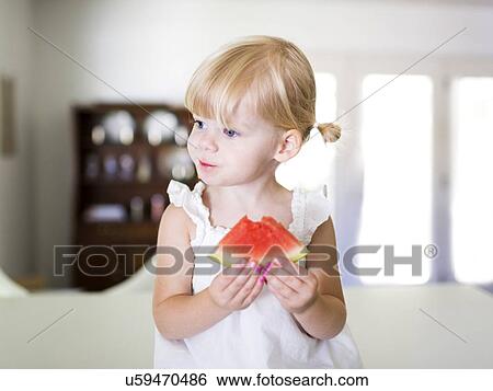 Stock Photograph - Portrait of girl (2-3) eating watermelon. Fotosearch