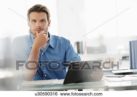 Portrait of mid-adult businessman working in office View Large Photo Image Stock Photograph - Portrait of mid-adult businessman working in office. Fotosearch