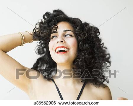 Stock Photograph - Portrait of smiling woman with dark curly hair. Fotosearch