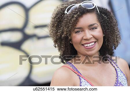 Portrait of smiling young woman with curly hair View Large Photo Image Stock Photography - Portrait of smiling young woman with curly hair. Fotosearch