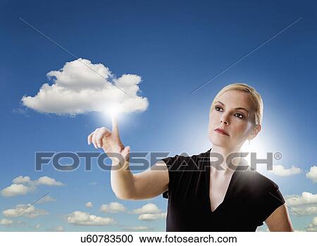 Stock Image - Portrait of woman touching cloud. Fotosearch