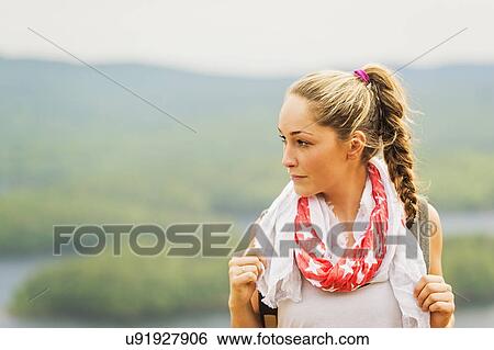 Portrait of young woman against green landscape View Large Photo Image Stock Photograph - Portrait of young woman against green landscape. Fotosearch