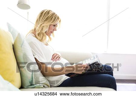 Pregnant woman reading book at home View Large Photo Image Picture - Pregnant woman reading book at home. Fotosearch