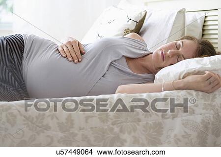 Pregnant woman sleeping in bed View Large Photo Image Picture - Pregnant woman sleeping in bed. Fotosearch