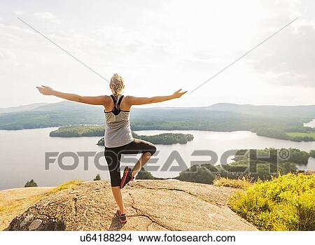Picture - Rear view of young woman exercising outdoor. Fotosearch