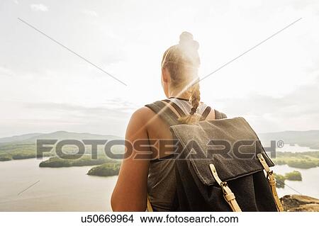 Picture - Rear view of young woman looking at lake. Fotosearch