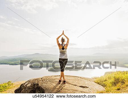 Rear view of young woman practicing yoga in front of lake View Large Photo Image Stock Image - Rear view of young woman practicing yoga in front of lake. Fotosearch