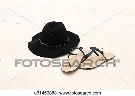 Sandals an sunhat on sand View Large Photo Image Stock Photo - Sandals an sunhat on sand. Fotosearch