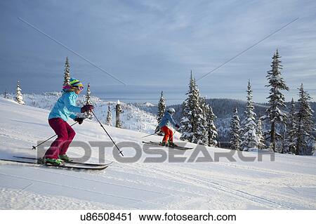Side view of skiing couple View Large Photo Image Stock Image - Side view of skiing couple. Fotosearch