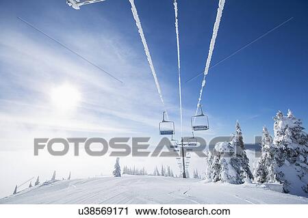 Ski lift at sunlight against blue ski View Large Photo Image Stock Image - Ski lift at sunlight against blue ski. Fotosearch