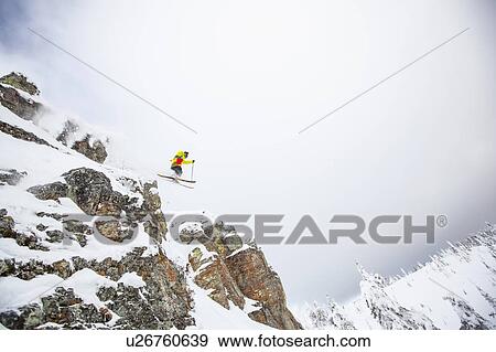 Skier jumping off rocky mountain View Large Photo Image Stock Photo - Skier jumping off rocky mountain. Fotosearch