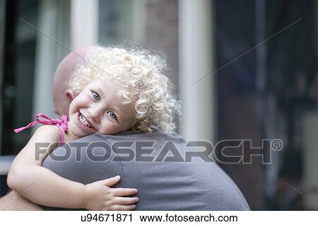 Stock Image - Smiley daughter (4-5) hugging father. Fotosearch