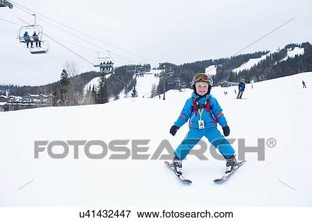 Stock Photo - Smiley little boy (5) at ski resort. Fotosearch