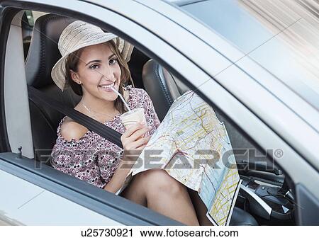 Smiling woman with map in car View Large Photo Image Stock Image - Smiling woman with map in car. Fotosearch