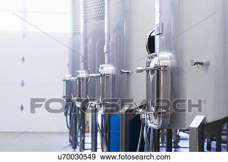 Stock Photo - Stainless steel tanks in winery cellar. Fotosearch
