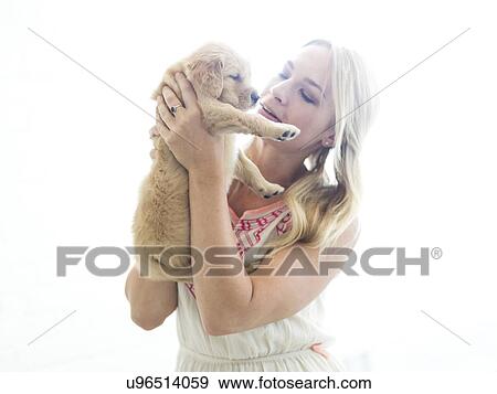 Studio shot of Golden Retriever puppy with owner View Large Photo Image Stock Photo - Studio shot of Golden Retriever puppy with owner. Fotosearch