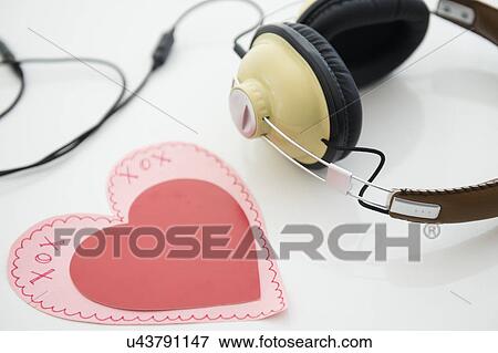 Stock Photo - Studio shot of heart shaped paper cutout and headphones. Fotosearch