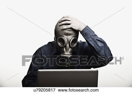 Studio shot of man in front of laptop wearing gas mask View Large Photo Image Stock Photo - Studio shot of man in front of laptop wearing gas mask. Fotosearch