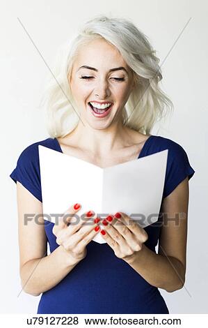 Studio shot of woman holding paper View Large Photo Image Stock Photo - Studio shot of woman holding paper. Fotosearch