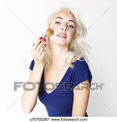 Stock Photo - Studio shot of woman using make-up brush. Fotosearch