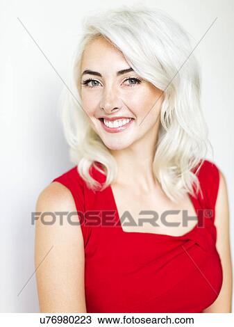 Stock Image - Studio shot of woman wearing red dress. Fotosearch
