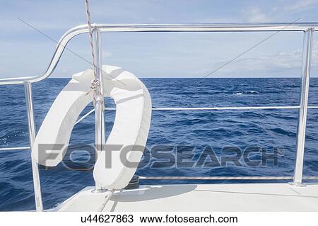 Stock Image - View from luxury yacht with railing and lifebelt in foreground. Fotosearch