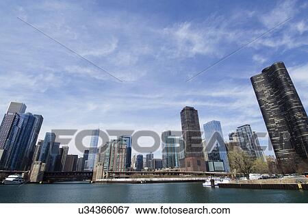 Waterfront cityscape under blue sky View Large Photo Image Stock Photo - Waterfront cityscape under blue sky. Fotosearch