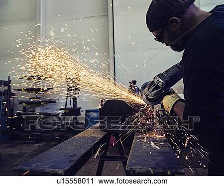 Stock Image - Welder working in metal workshop. Fotosearch
