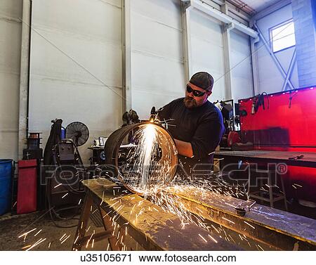 Stock Image - Welder working in metal workshop. Fotosearch