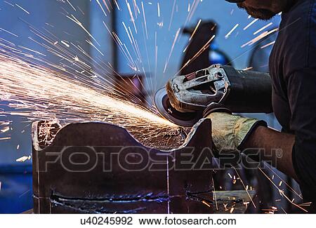 Stock Image - Welder working in metal workshop. Fotosearch