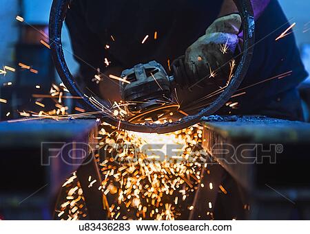 Stock Image - Welder working in metal workshop. Fotosearch