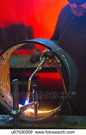 Welder working in metal workshop View Large Photo Image Stock Photo - Welder working in metal workshop. Fotosearch