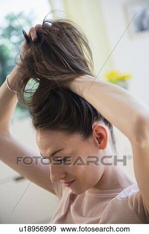 Stock Photo - Woman doing her hair. Fotosearch