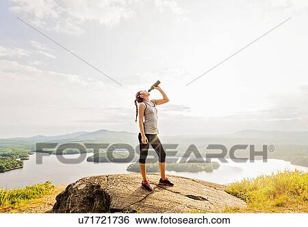 Woman drinking water after doing exercises View Large Photo Image Stock Photograph - Woman drinking water after doing exercises. Fotosearch