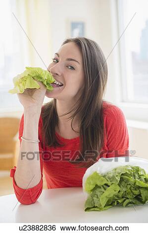 Stock Photograph - Woman eating lettuce. Fotosearch
