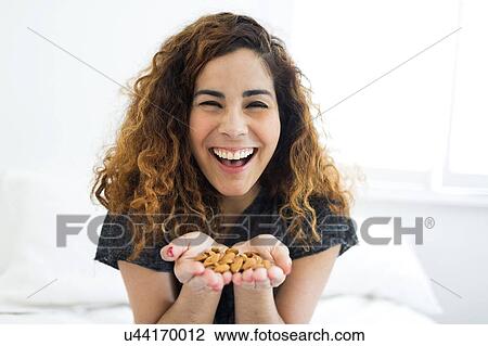 Stock Image - Woman holding almonds. Fotosearch