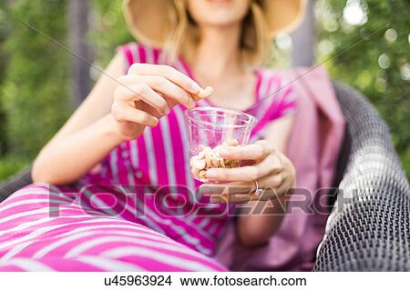 Picture - Woman holding snacks. Fotosearch