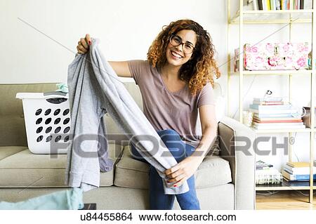 Picture - Woman holding trousers. Fotosearch