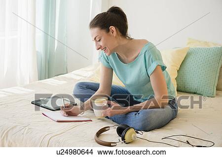 Woman in bedroom working View Large Photo Image Picture - Woman in bedroom working. Fotosearch