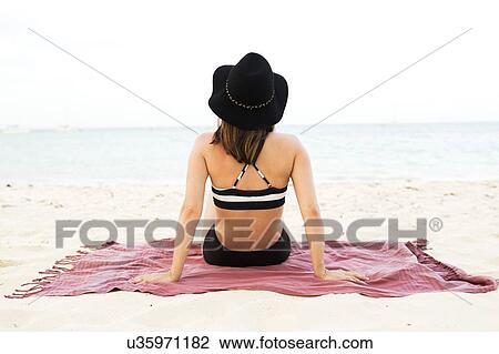 Woman in bikini relaxing on beach View Large Photo Image Stock Image - Woman in bikini relaxing on beach. Fotosearch