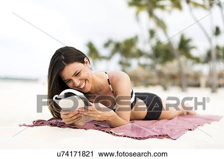 Woman in bikini relaxing on beach View Large Photo Image Stock Image - Woman in bikini relaxing on beach. Fotosearch