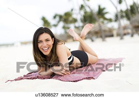 Woman in bikini relaxing on beach View Large Photo Image Stock Photo - Woman in bikini relaxing on beach. Fotosearch