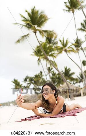 Stock Photo - Woman in bikini relaxing on beach. Fotosearch