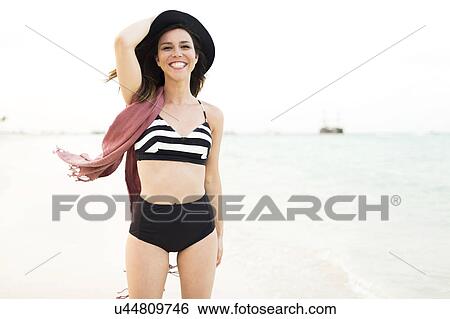 Stock Photograph - Woman in bikini relaxing on beach. Fotosearch