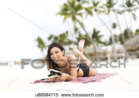 Stock Photography - Woman in bikini relaxing on beach. Fotosearch