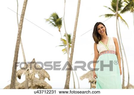 Stock Image - Woman in dress on beach. Fotosearch