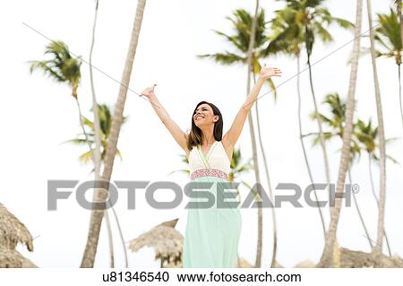 Stock Image - Woman in dress on beach. Fotosearch
